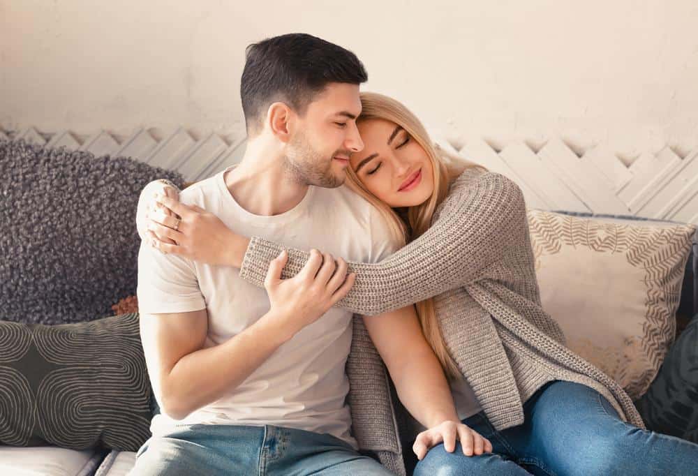 September 30, 2025 Happy Man And Woman Embracing On Sofa In Living Room