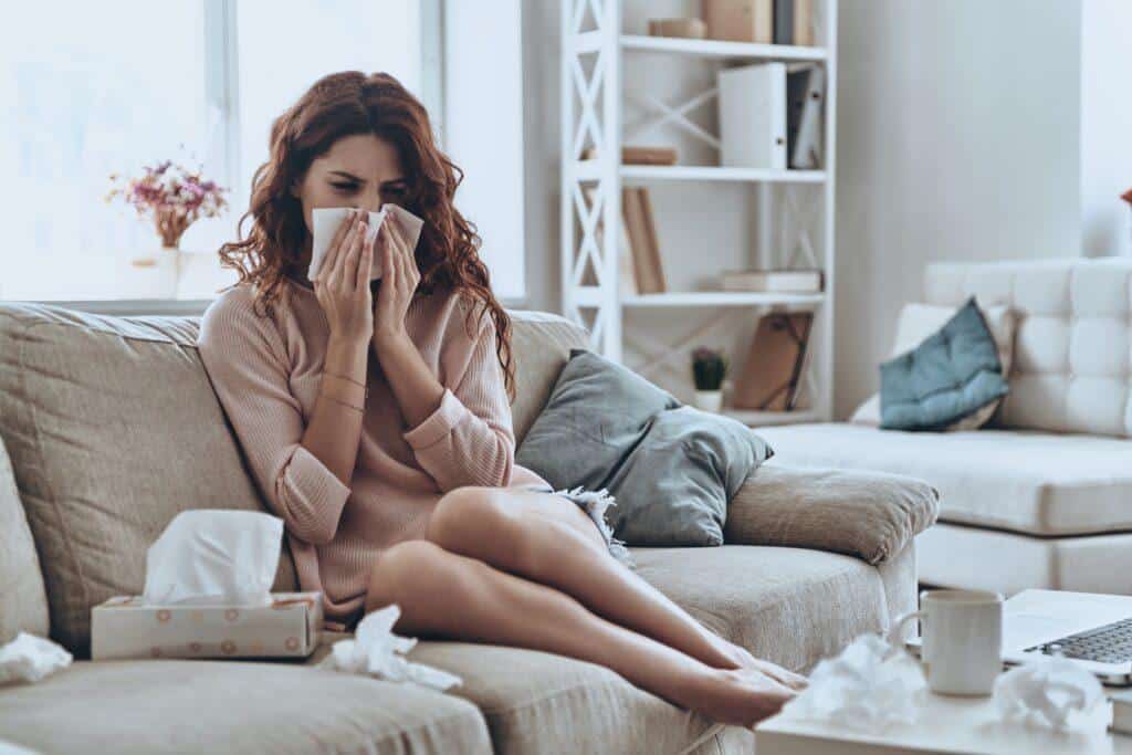 Flu Is Killing Me Sick Young Women Blowing Her Nose Using Facial Tissues While Sitting On The Sofa At Home