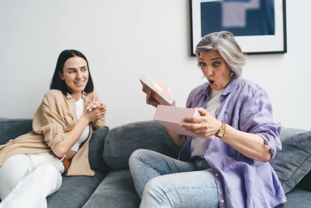 November 6, 2025 Young Woman With Wondering Mother Sitting On Sofa At Home